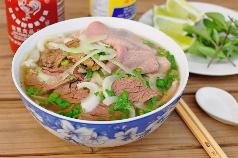 Bát phở bò nóng hổi với bánh phở mềm và thịt bò thái mỏng