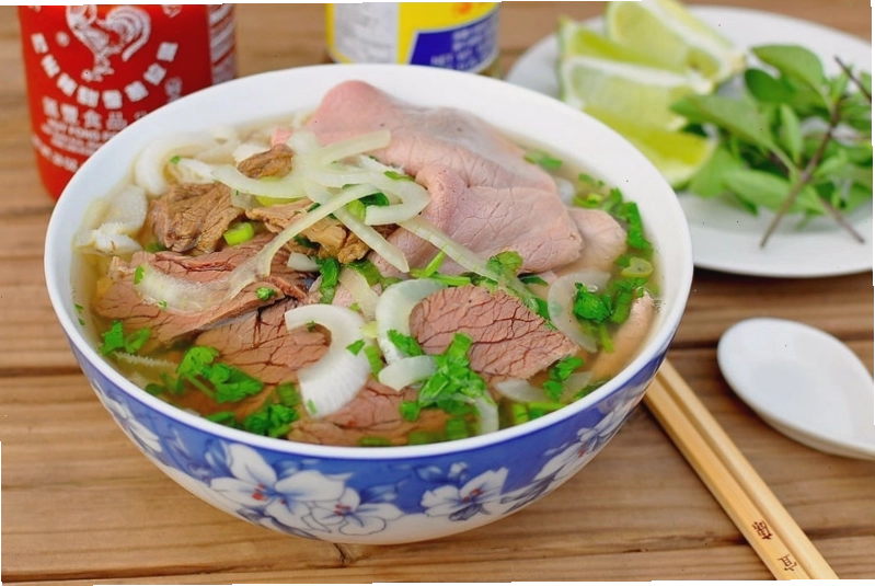 Bát phở bò tái nóng hổi với hành lá xanh mướt, một biểu tượng của ẩm thực Hà Nội