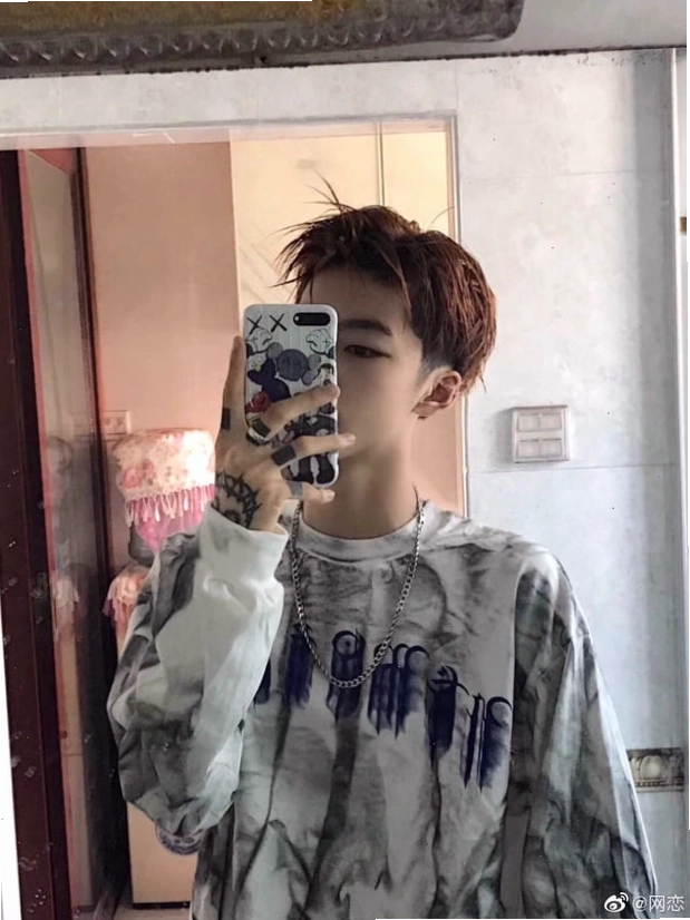 Chàng trai dùng điện thoại che mặt thể hiện phong cách cool ngầu