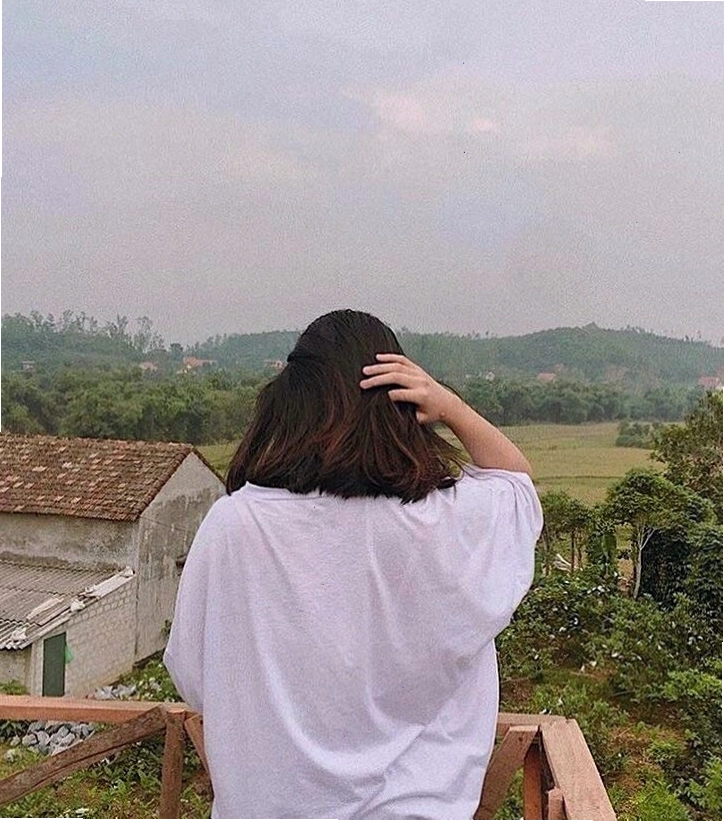 Cô gái đứng quay lưng lại, hai tay ôm lấy đầu, thể hiện sự mệt mỏi và u sầu