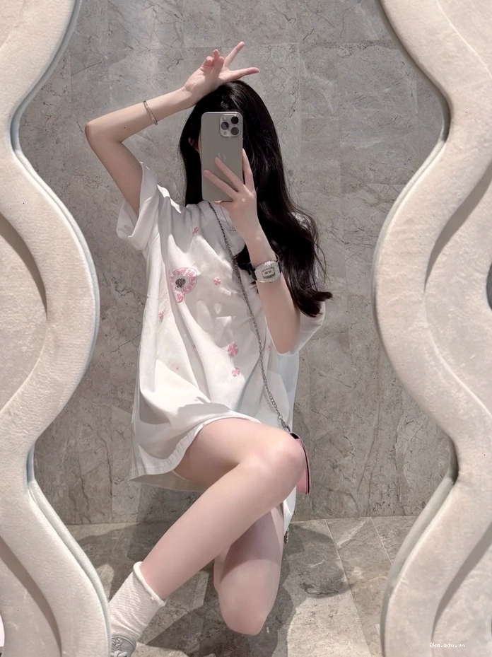Cô gái xinh selfie trước gương và dùng điện thoại che mặt