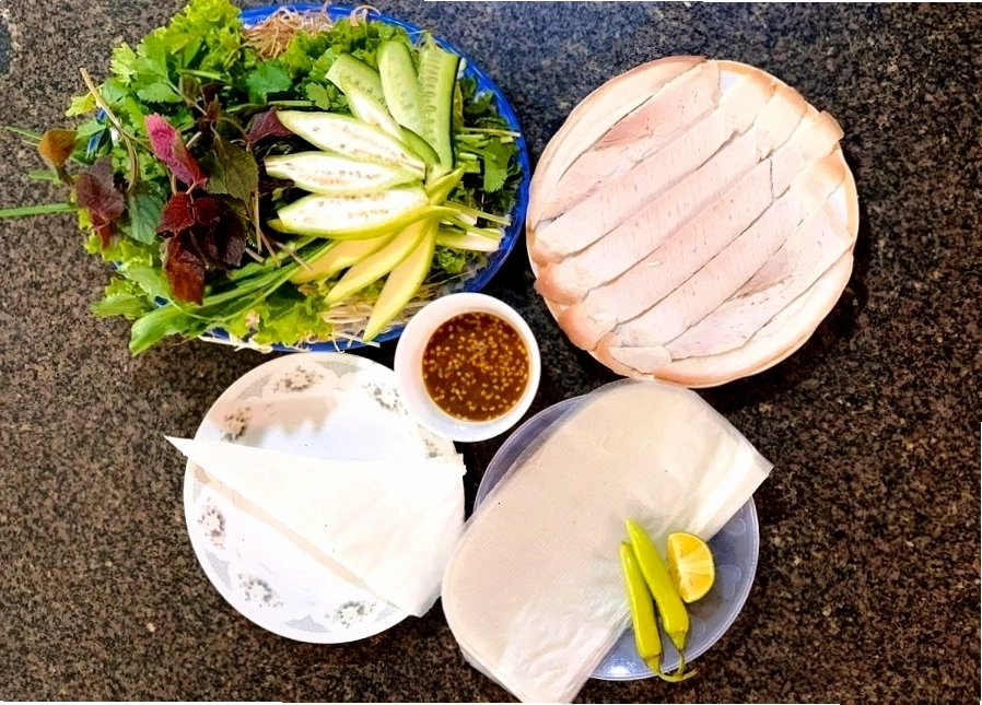 Đĩa bánh tráng cuốn thịt heo với đầy đủ rau sống và mắm nêm