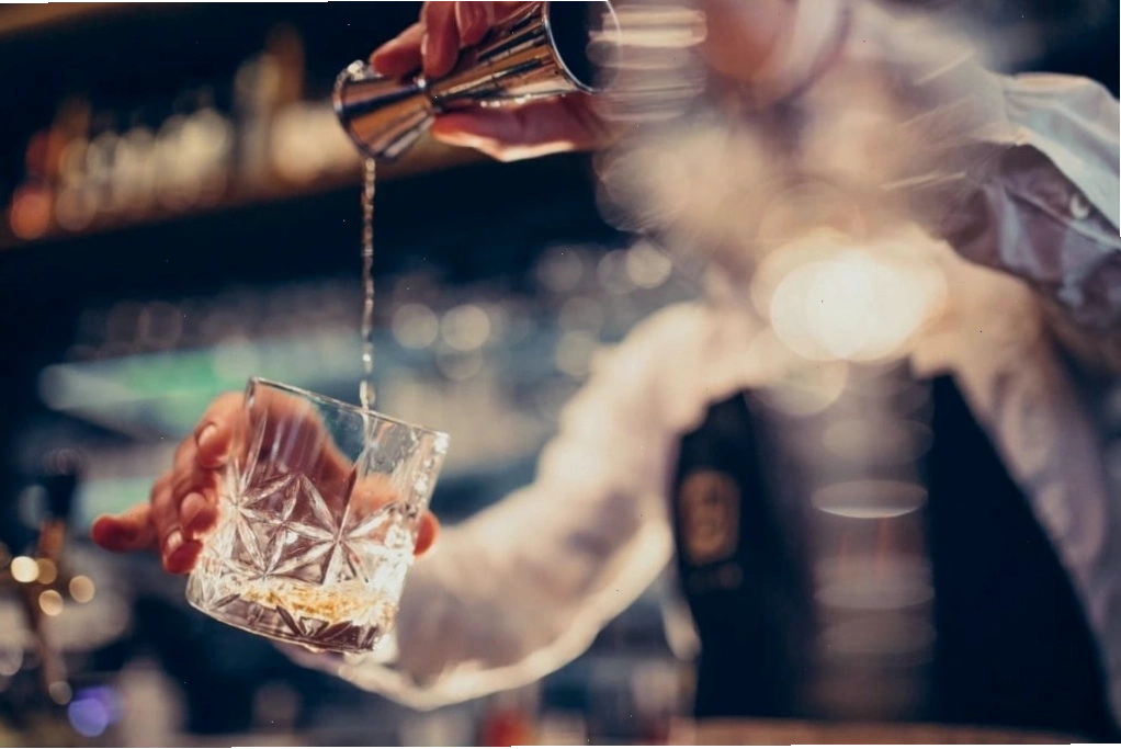 Nhân viên pha chế đồ uống (bartender) đang thực hiện công việc tại quầy bar