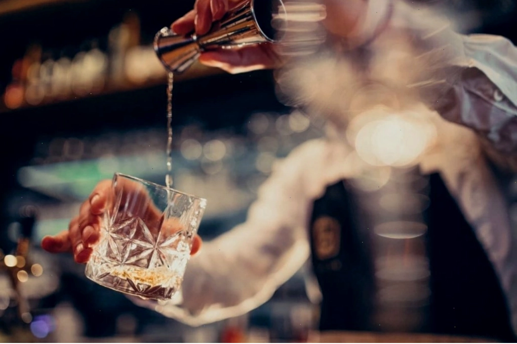 Nhân viên pha chế đồ uống đang chuẩn bị thức uống tại quầy bar