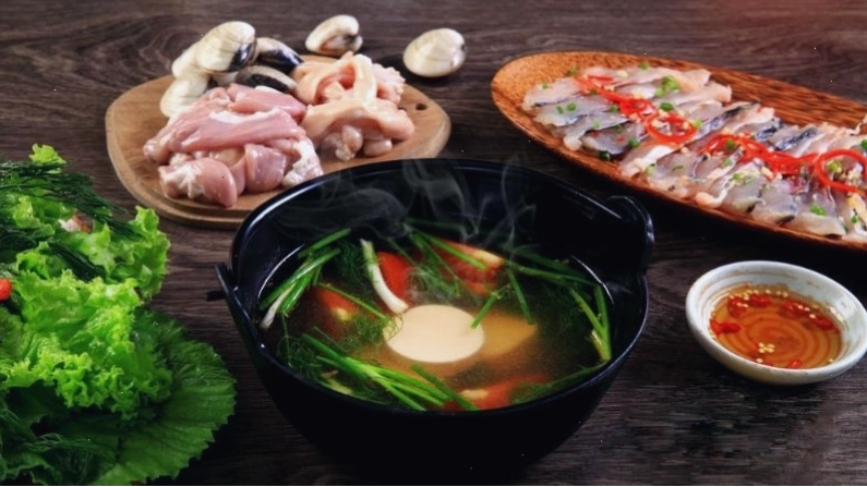 Nồi lẩu cá trắm hấp dẫn với nước dùng chua ngọt và các loại rau tươi ngon